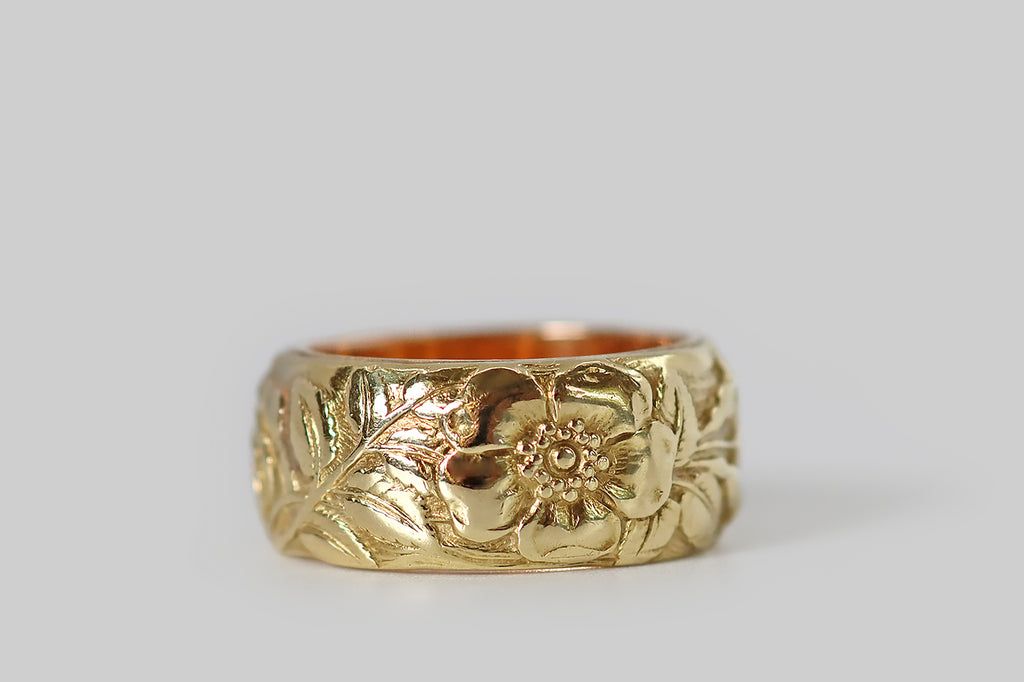 Poor Mouchette | Curated Antique Jewelry, Vintage Jewelry & Engagement Rings | Portland, Oregon |A rare and wonderful Art Nouveau era wide band ring, modeled in 14k yellow gold, whose face is decorated with a series of images (in relief) that represent the astrological sign Cancer. Among these beautifully carved figures is a gentle crab, a pair of wild roses, and Cancer's astrological glyph. The carving here is masterful