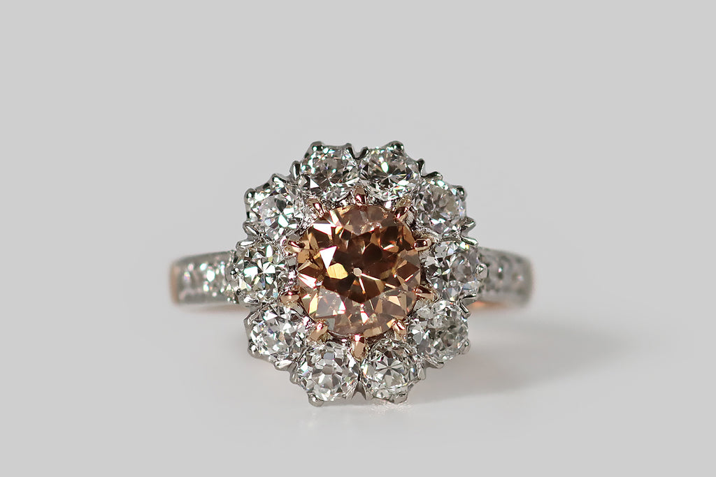 Poor Mouchette | Curated Antique Jewelry, Vintage Jewelry & Engagement Rings | Portland, Oregon | An Edwardian-era, flower-form cluster ring, modeled in 18k rose gold and platinum, whose primary gem is a .90 carat natural, fancy brown, old mine cushion cut diamond. This antique diamond is a beautiful, highly-saturated, peachy-brown color— it is held in ten, tapering rose gold prongs, where it is surrounded by a series of ten white old European cut diamonds.