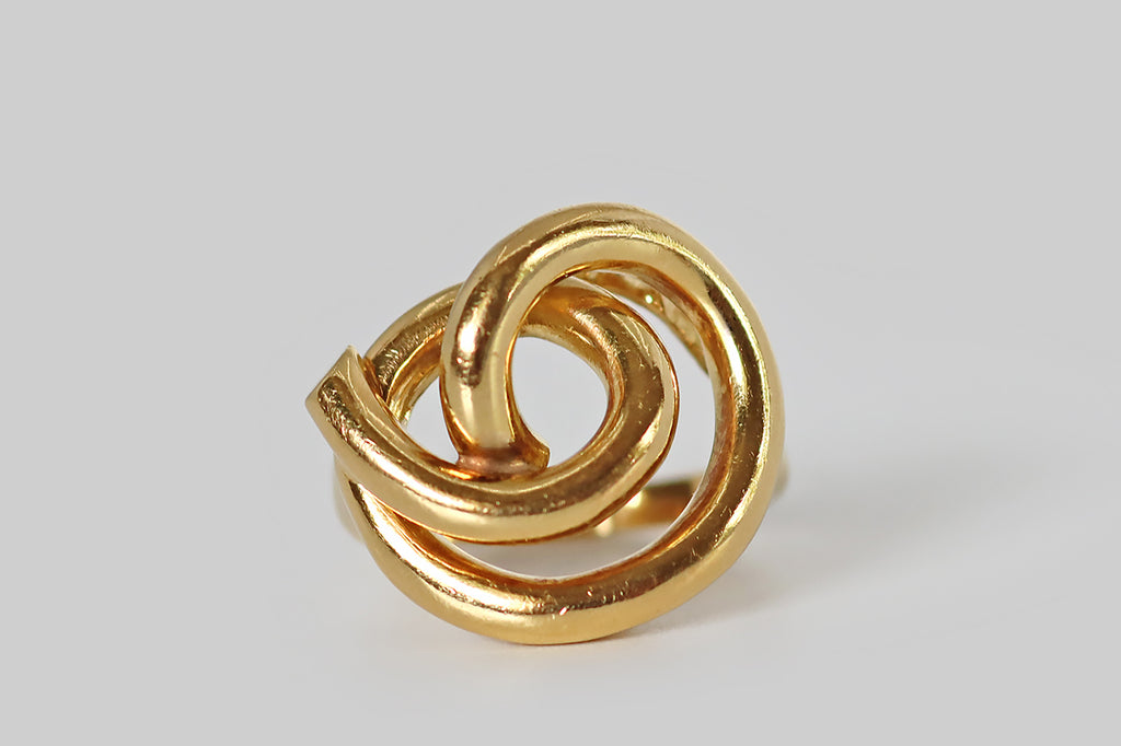 Poor Mouchette | Curated Antique Jewelry, Vintage Jewelry & Engagement Rings | Portland, Oregon | A mid 20th century ring, modeled in 18k yellow gold, whose coiled, spiraling form suggests the beginning of a knot. This tube-like, three-dimensional form covers the wearer's finger— it loops twice before threading through those two loops, remaining loose, and visually open atop the ring's pierced gallery. 