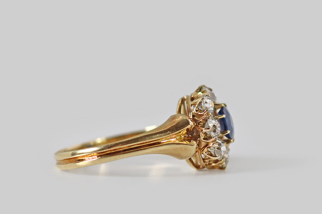 Poor Mouchette | Curated Antique Jewelry, Vintage Jewelry & Engagement Rings | Portland, Oregon | A wonderful, Victorian-era, flower-form cluster ring, modeled in 18k yellow gold, whose primary gem is a natural, old-mine-cushion-cut sapphire. This highly-saturated, deep blue gem is held in tapering prongs, where it is surrounded by a series of eight sparkling, old European cut diamonds (G/H, VS-SI).