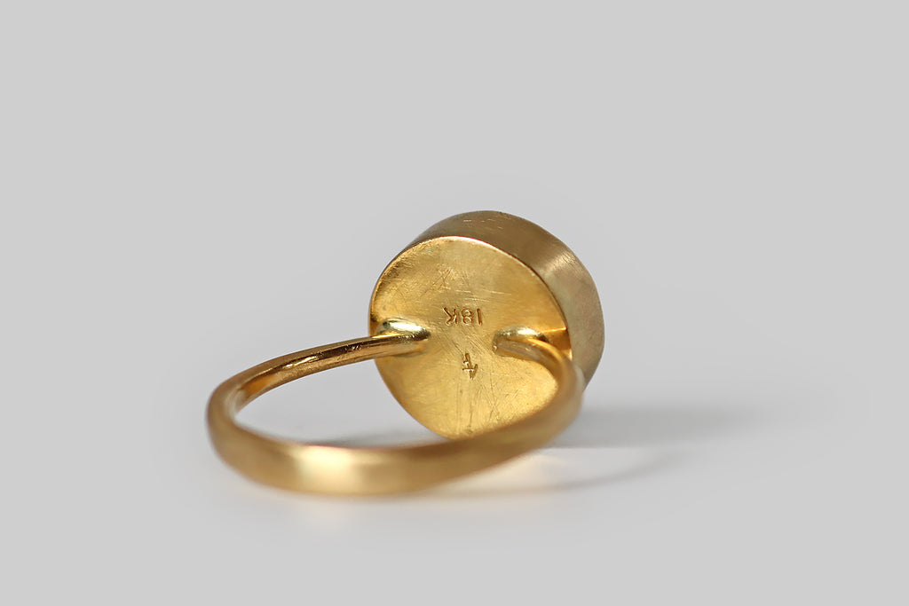 Antique Jewelry Portland, Vintage Jewelry Portland , Antique Engagement Rings | Poor Mouchette | A striking contemporary ring, modeled in 18k yellow gold, by the designer&nbsp;Annette Ferdinandsen. This signet-style ring features a carved yellow beryl gem, whose intaglio subject is a tiny hummingbird in flight— this is a reverse carving, so the little bird is carved on the underside of the stone, where he stands out against the brushed, high-color surface of the ring's closed back setting.