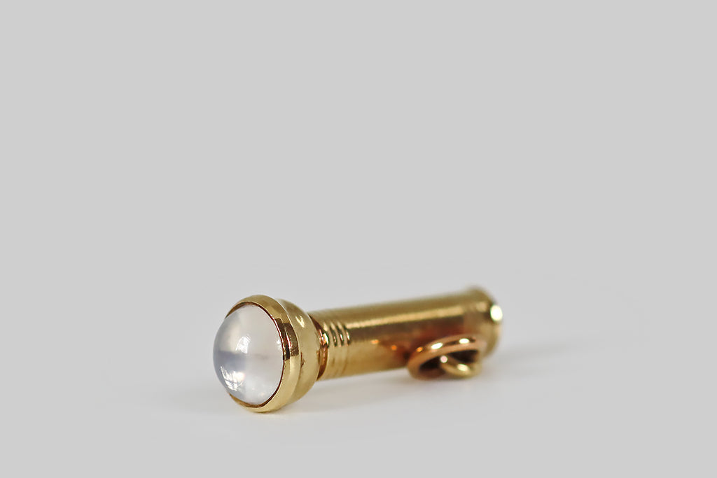 Poor Mouchette | Curated Antique Jewelry, Vintage Jewelry & Engagement Rings | Portland, Oregon | A dainty, mid 20th century charm, modeled in 14k yellow gold, as a flashlight, with a blue-flash moonstone “lens.” This miniature watchman’s flashlight is a rarity. It is beautifully made and full of symbolic potential— we think it’s about finding your way in the dark, but you may see another metaphor that hovers around the idea of light.